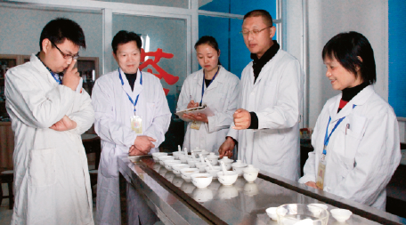 201608-7邱虎(右二)向其他品茶师介绍自己对茶叶味道的看法.png