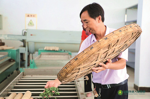 徐从德在茶厂里对刚杀青的茶叶进行再加工。_副本.jpg