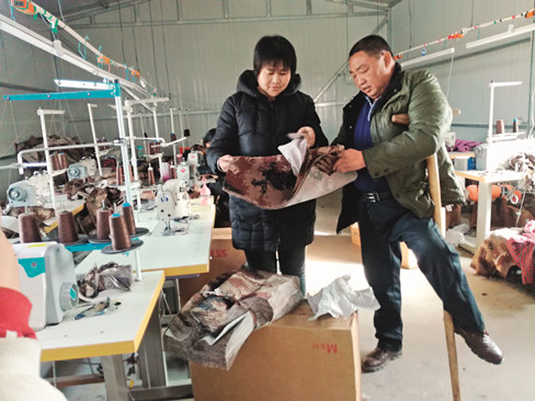 在瑞浩扶残助困加工厂服装车间里，吕文书（右）正在和工人研究新的服装样式。_副本.jpg